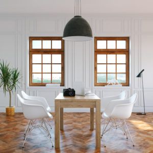 modern dining area with white chairs and table in front of wood-framed windows