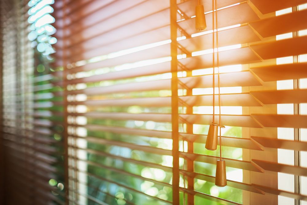 sun’s rays shining through wooden blinds