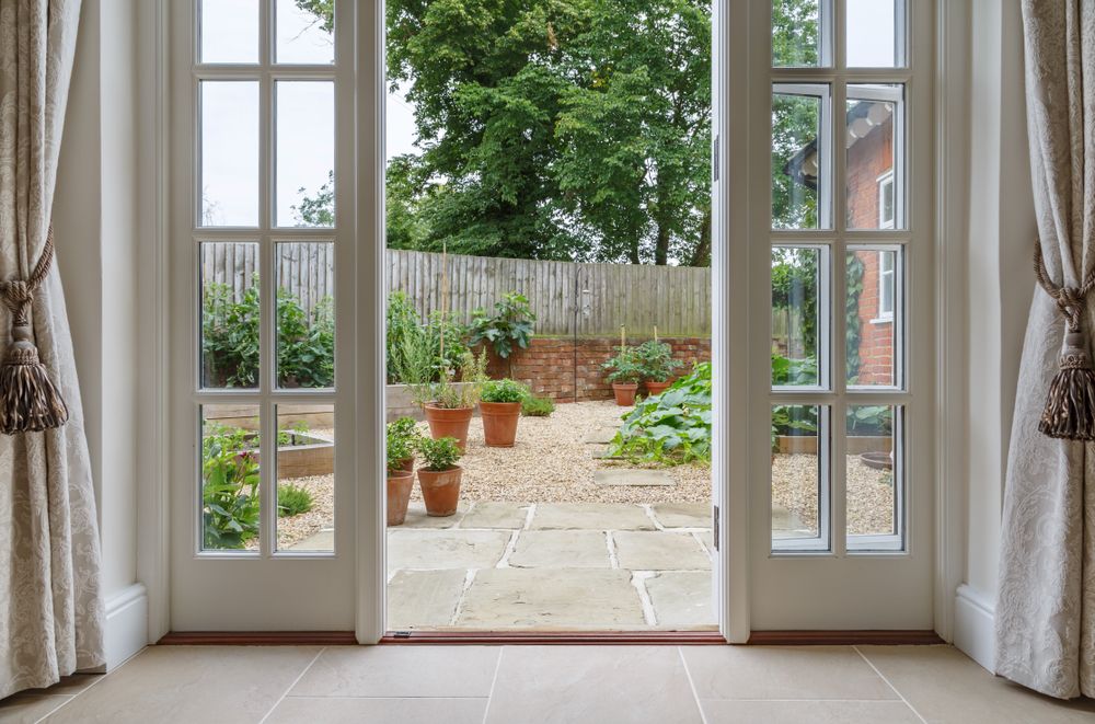 Hinged patio doors open to garden in backyard.