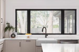 A kitchen detail with brown cabinets and a black faucet on a farmhouse sink